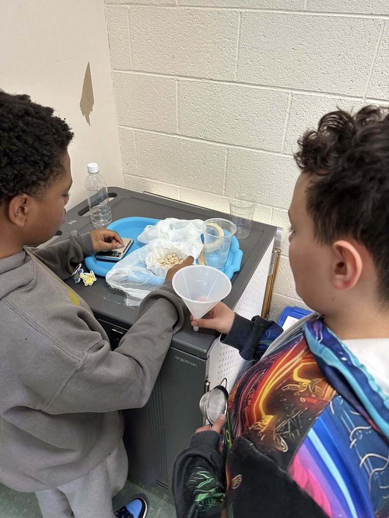 Kids in a classroom doing a experiment. 