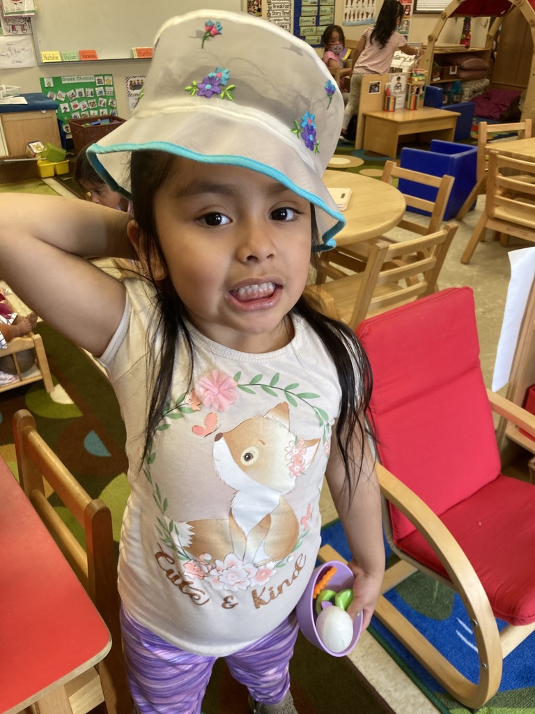 A little girl is dressed up with a fun hat.