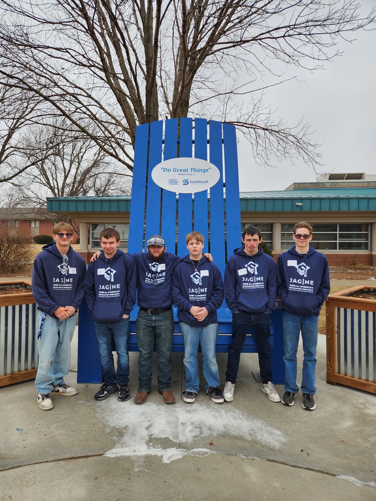 Students in attendance posing in front of the large SCC chair