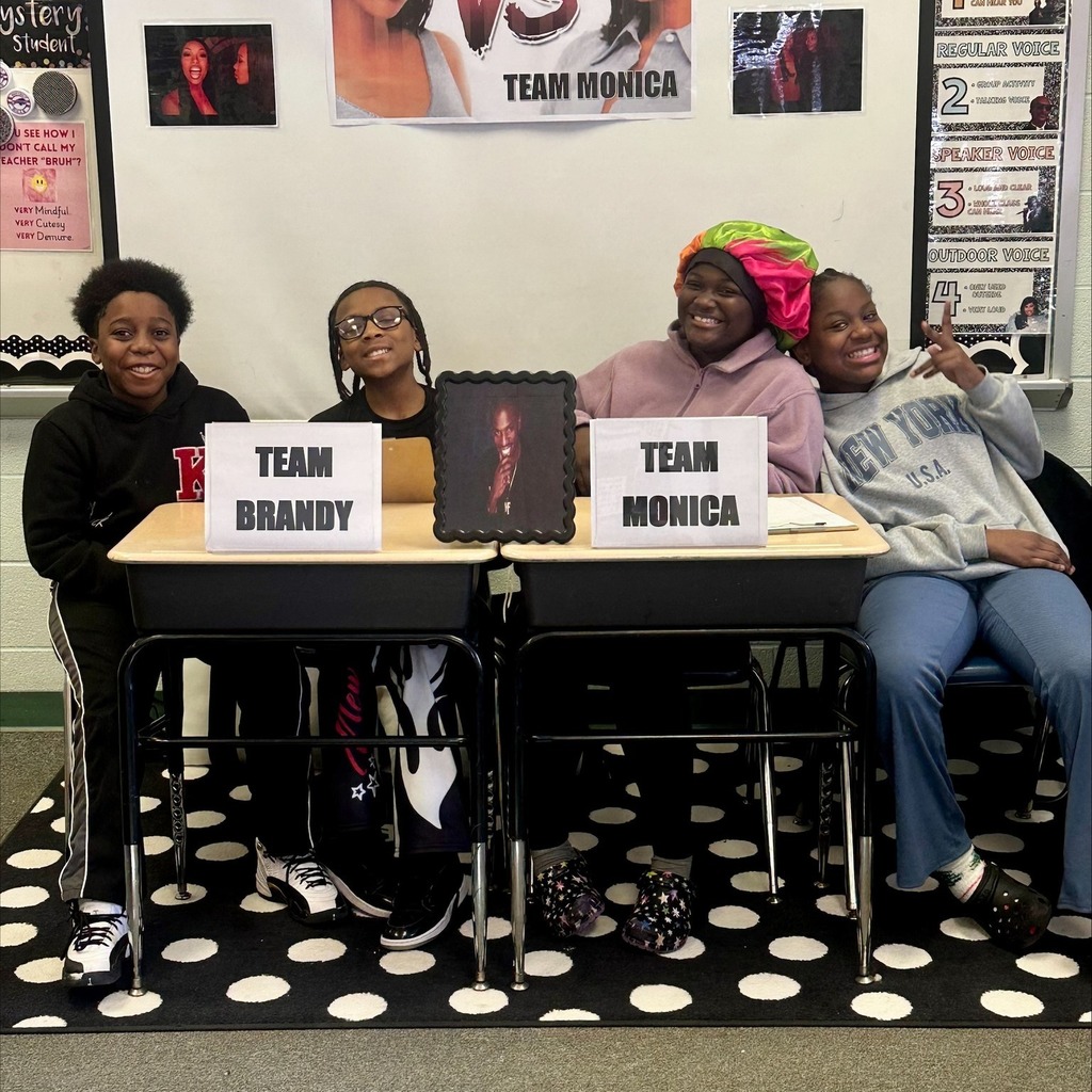 Two young boys on one team sitting on the left and two young girls on another team sitting on the right. 