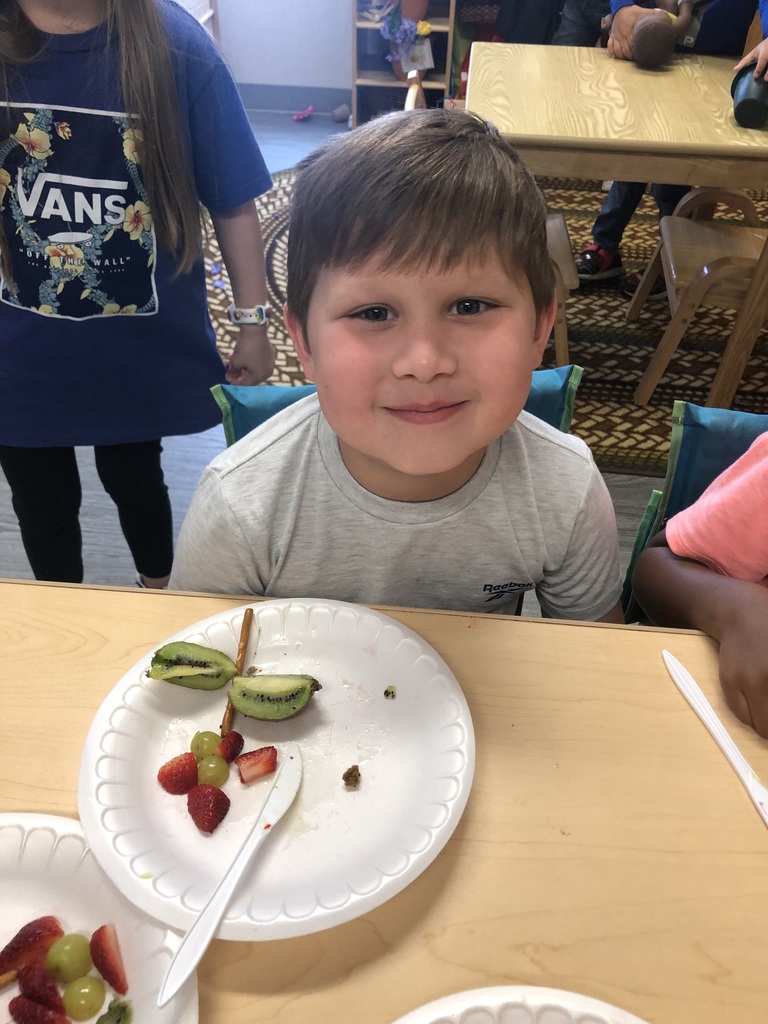 A little boy made a flower with fruit.