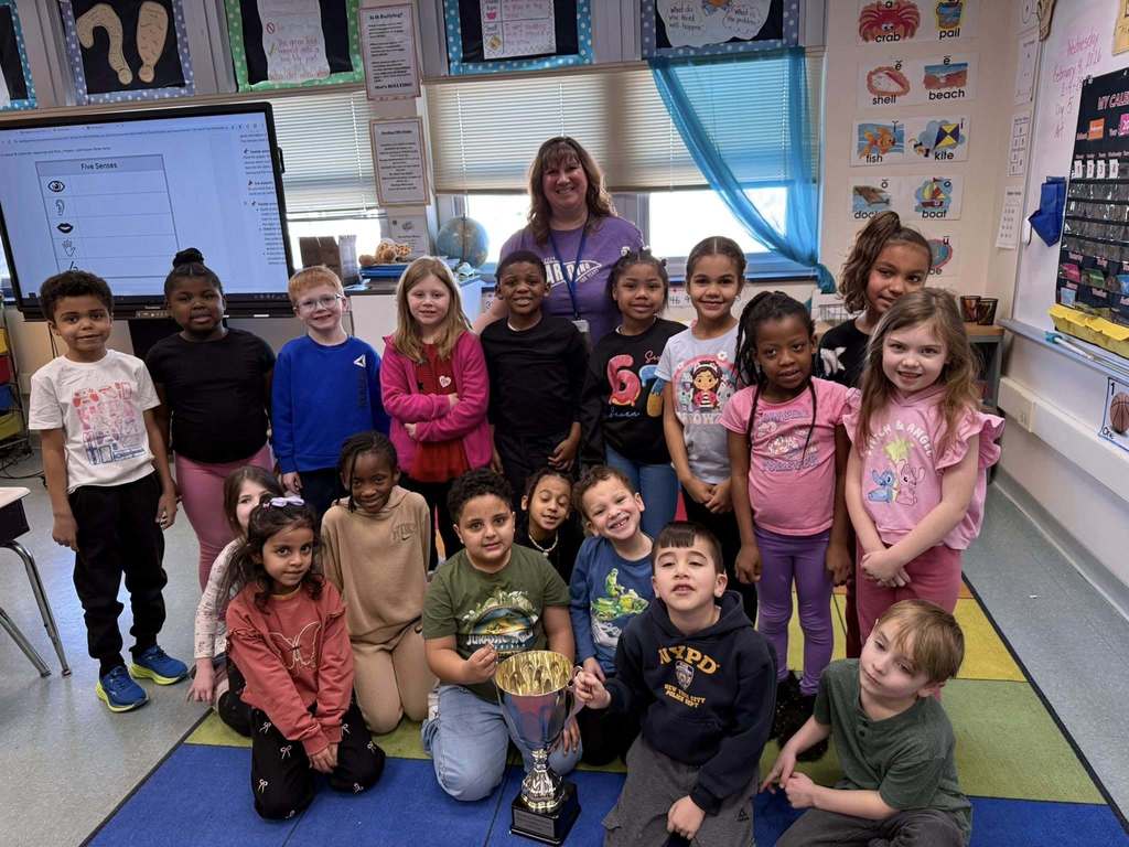 A group of students and an adult in a classroom.