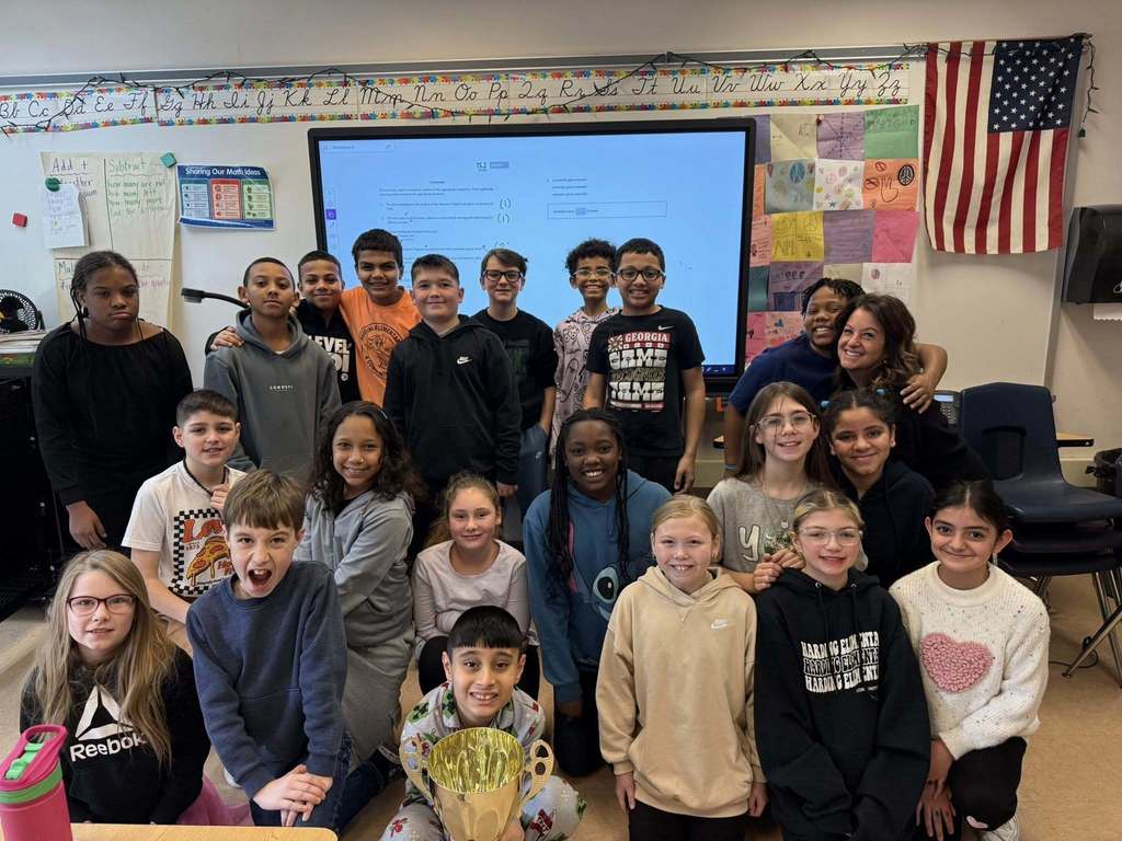 A group of students and an adult in a classroom.