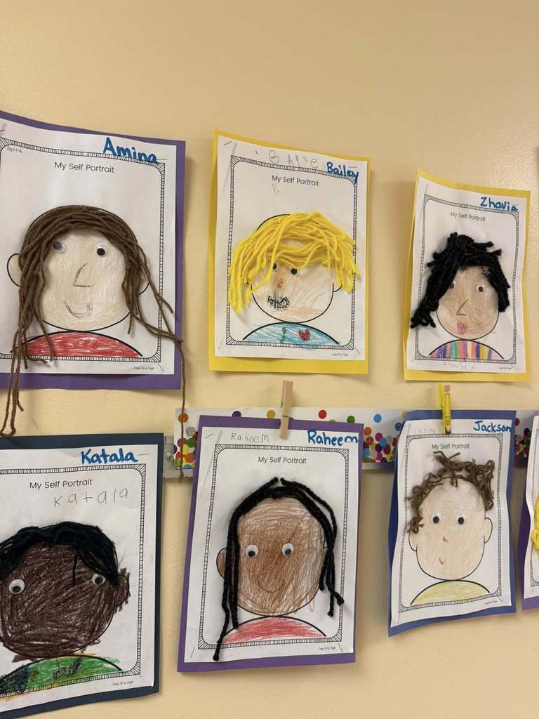 Drawings displayed on a wall with hair made from string.