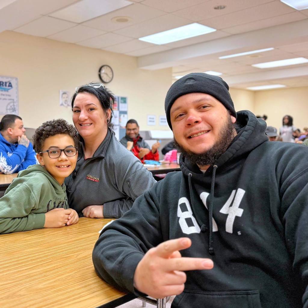 A kid smiling with his parents. 