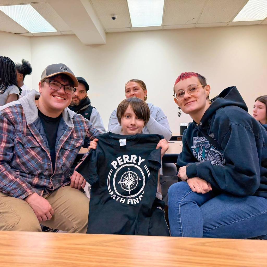 A kid smiling with his parents. 