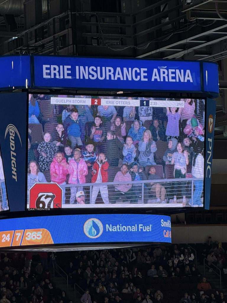 A group of students on a Erie Insurance Arena digital board.