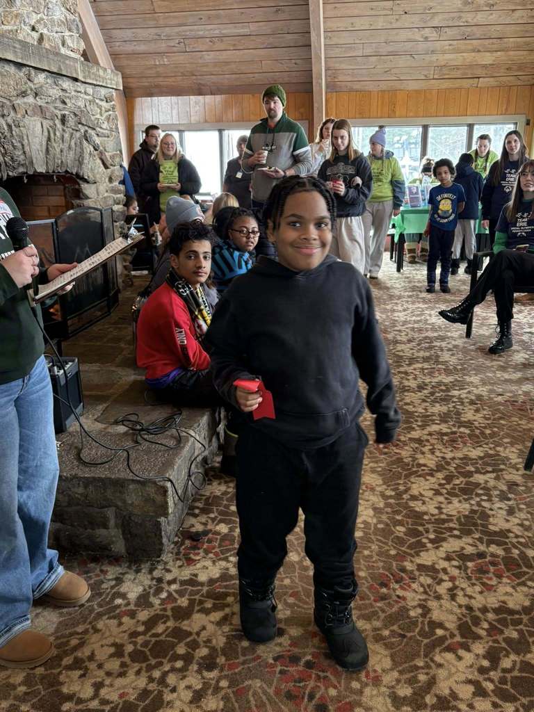 Young boy in a black hoodie holding his red ribbon. 