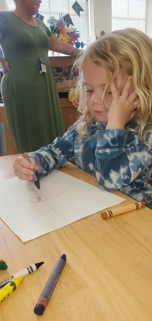 A little boy is drawing a picture of a person.
