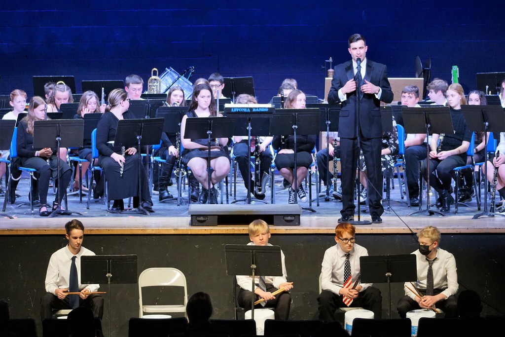 students on stage with conductor