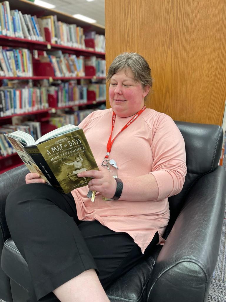 Mrs. Wickline is reading a book in the THS Media Center.