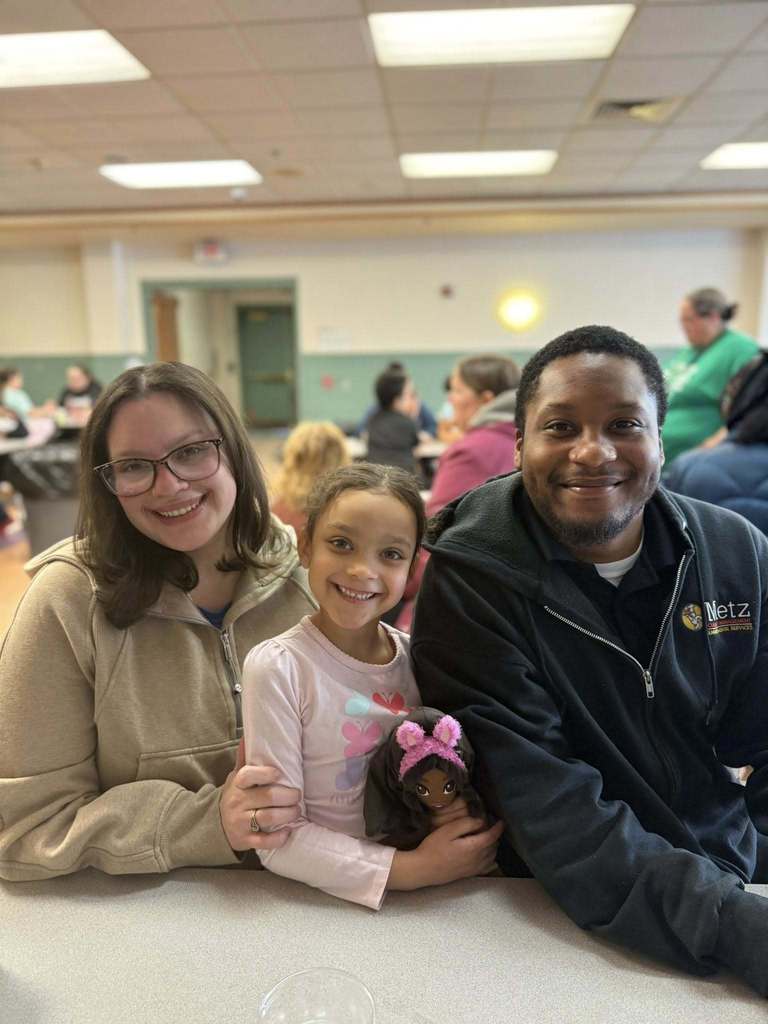 A young girl sitting in between her parents.
