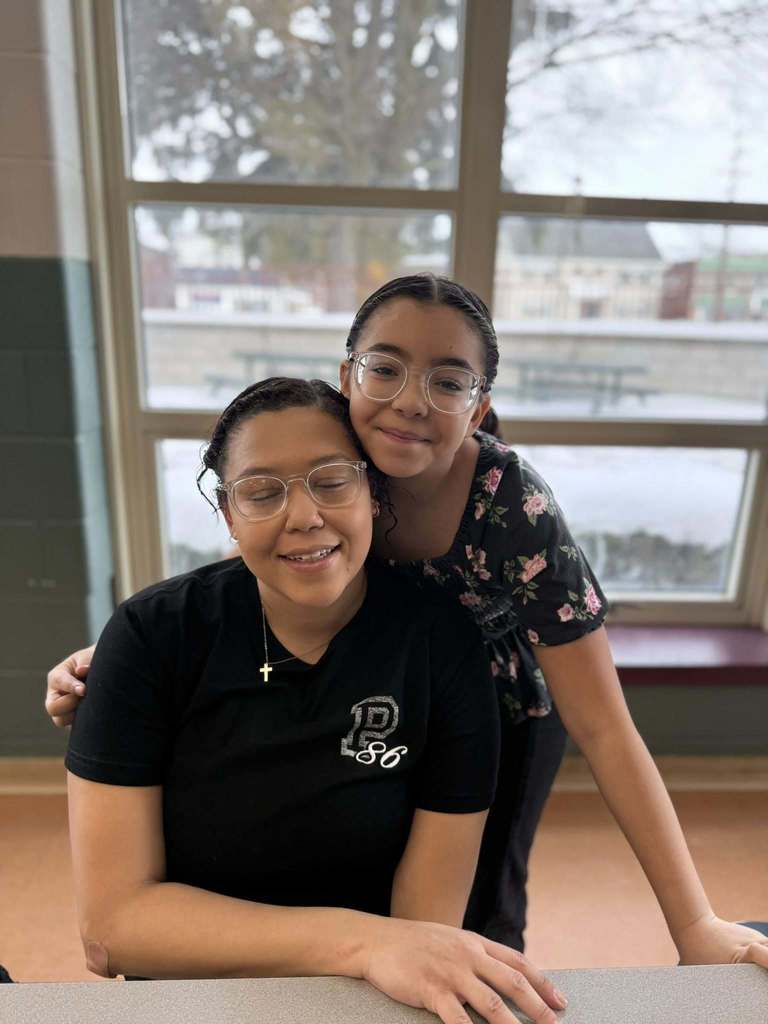 A young girl hugging her mom.