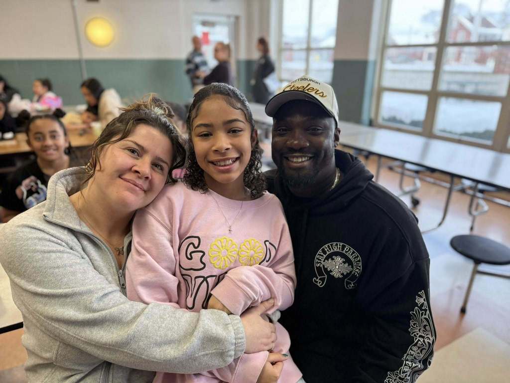 A young girl sitting between a man and women.