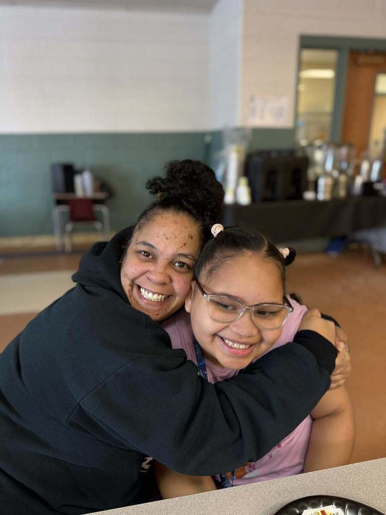 A mom hugging her daughter.