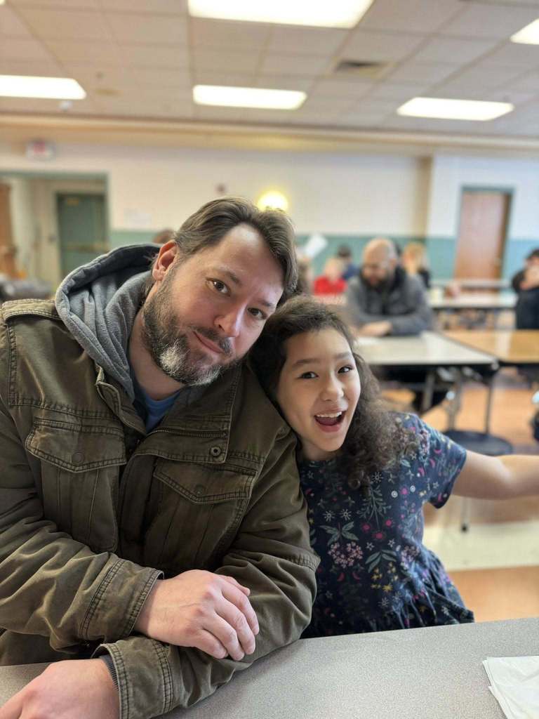 A young girl smiling with her dad.