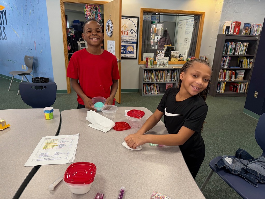 Kids playing with slime on a table in a library. 