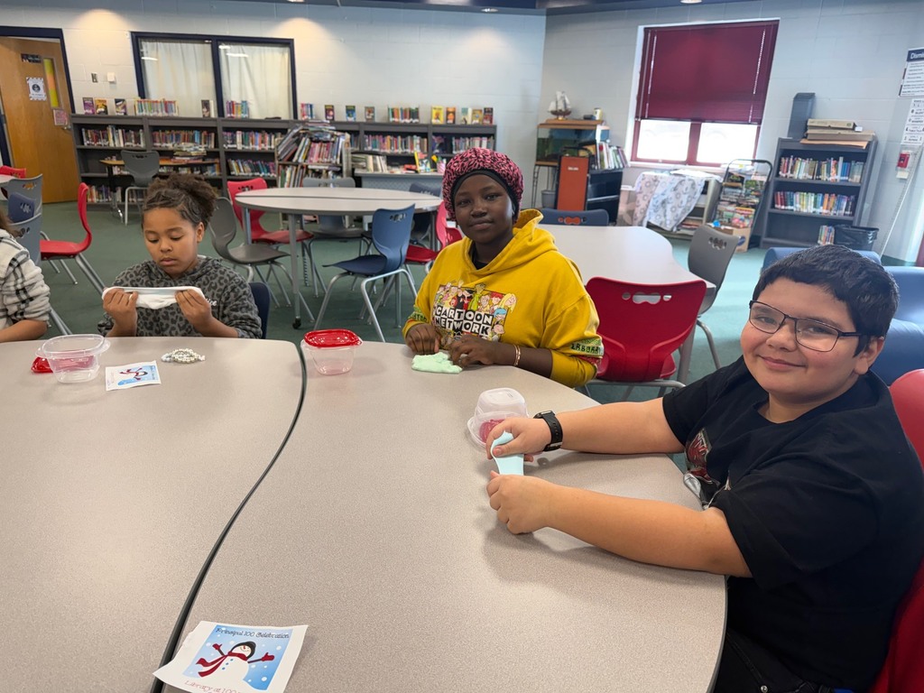 Kids playing with slime on a table in a library. 