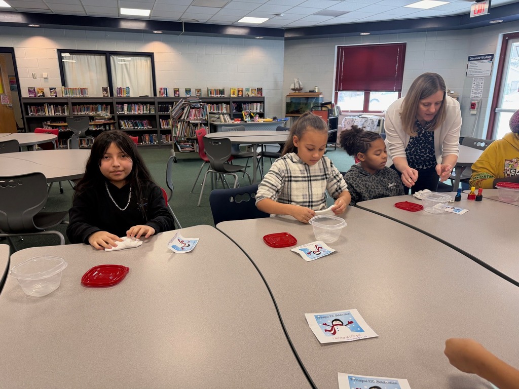 Kids playing with slime on a table in a library. 