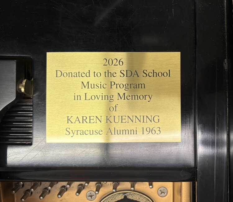 Plaque reading “2026 - Donated to the SDA School Music Program in Loving Memory of Karen Kuenning - Syracuse Alumni 1963