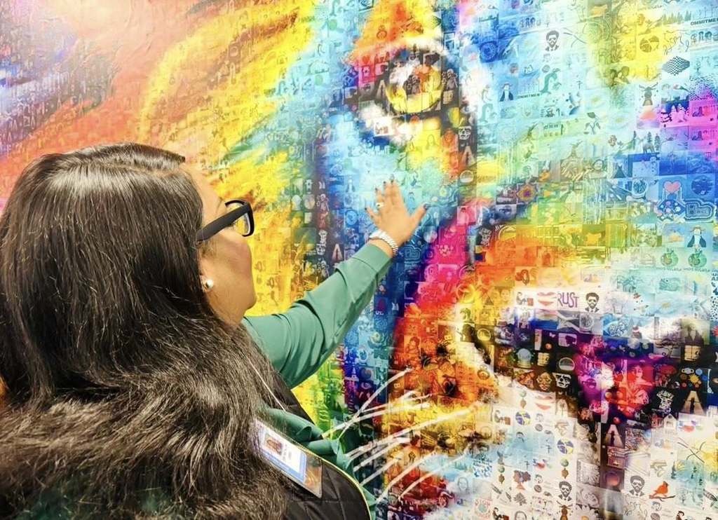 Woemn youching the art on the wall.