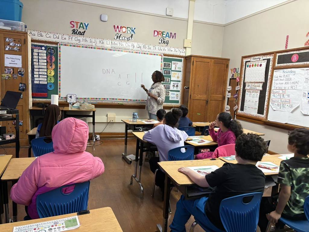 Kids in a classroom watching a teacher teach.