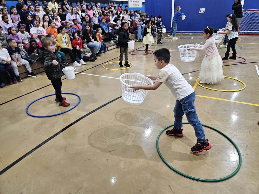 Kids and adults playing games in a gym.