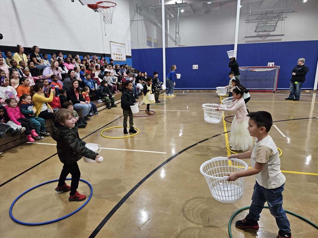 Kids and adults playing games in a gym.