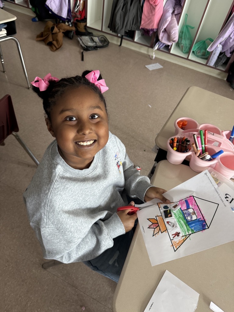 Young girl cutting paper and smiling.