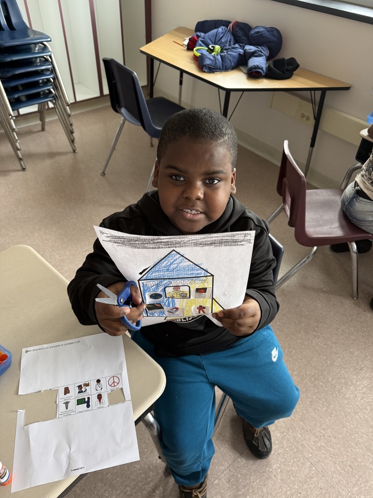 Young boy holding his art up.