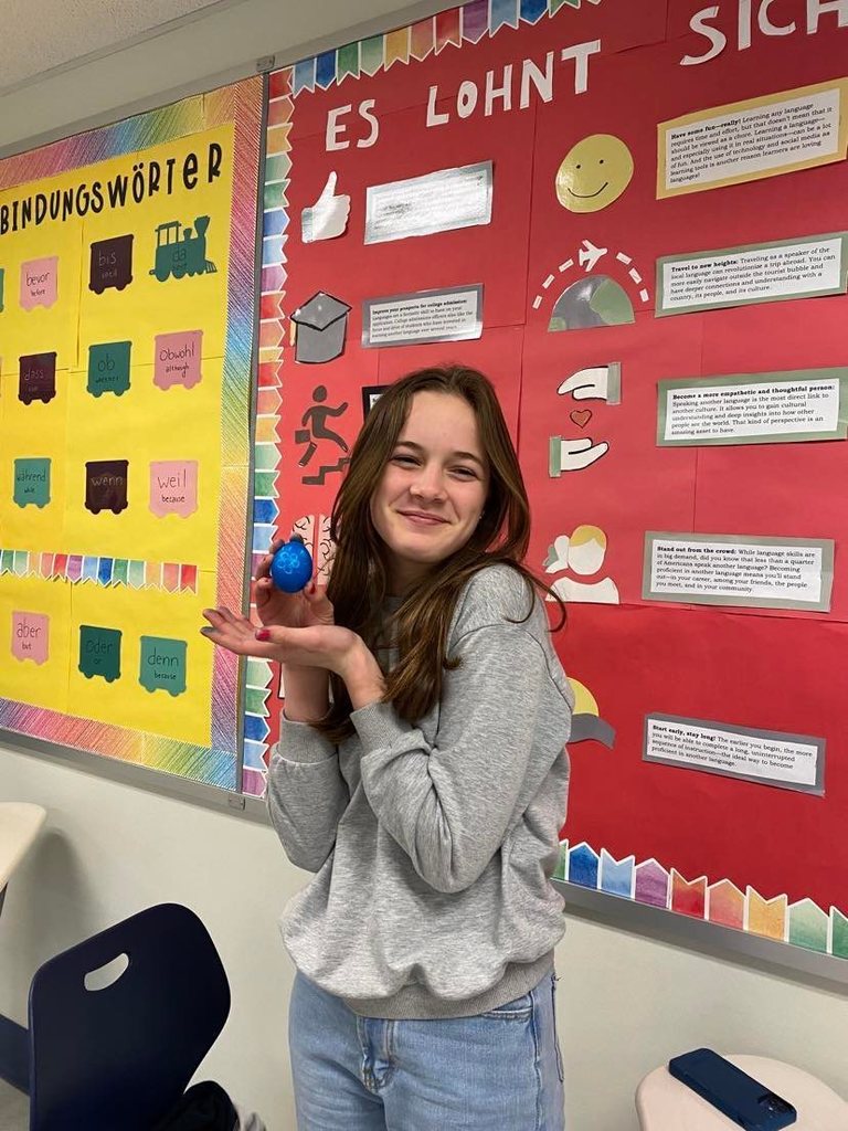High school students holding their dyed eggs.