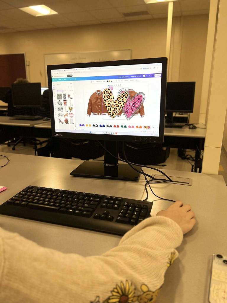 A student creating a design for a jacket on a computer.