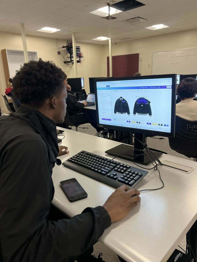 A student creating a design for a jacket on a computer.