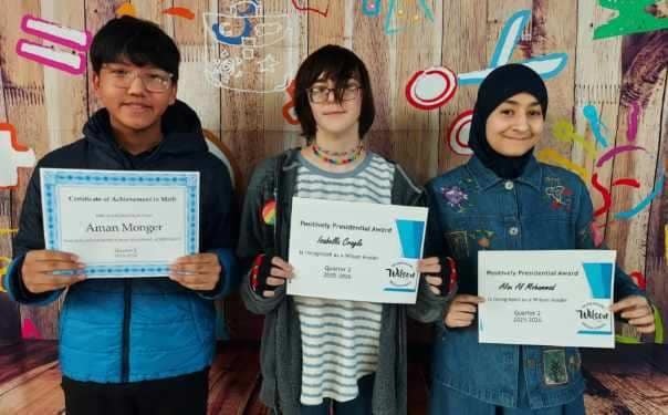 Kids standing and holding their certificates. 