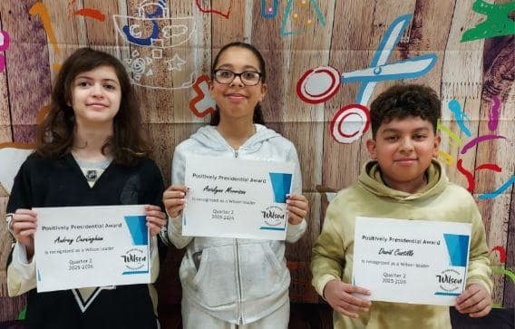 Kids standing and holding their certificates. 