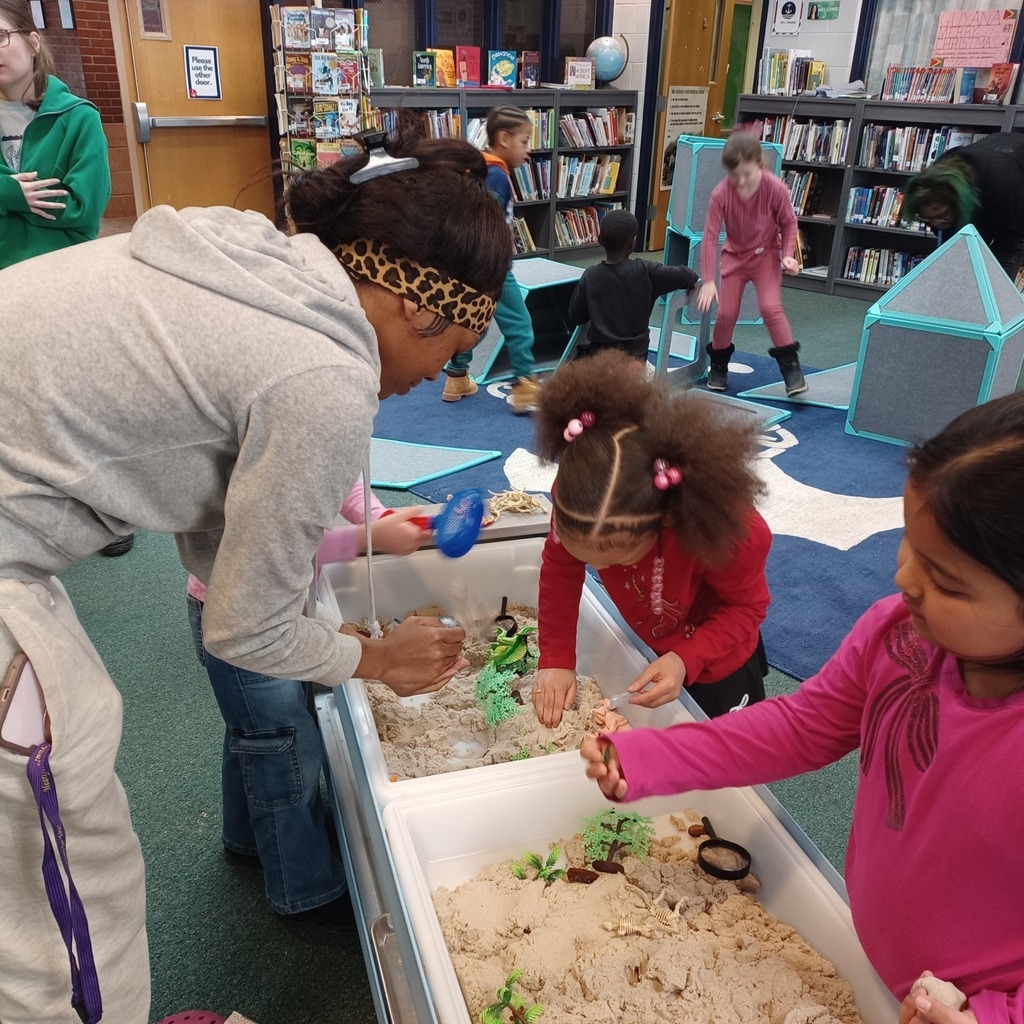 Kids playing with sand in a library.