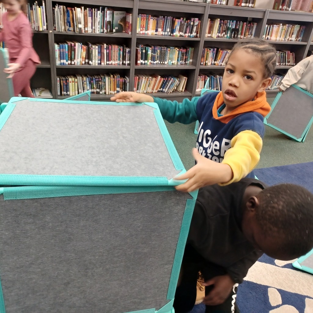 Kids playing with boxes in a library.