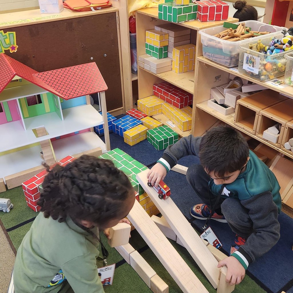 Kids playing with cars on a ramp. 