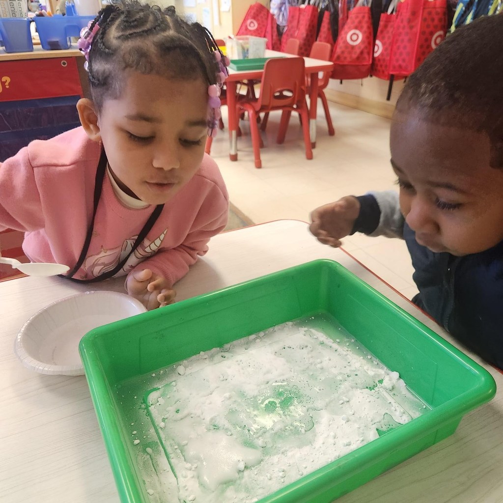 Students looking at the liquid and powder they mixed for an experiment in class.