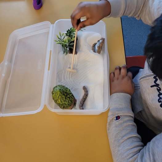 Child playing with a Zen garden.