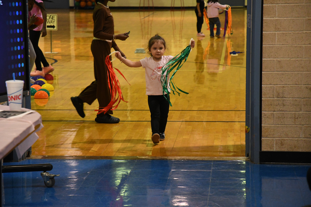 girl with streamers playing in the gym