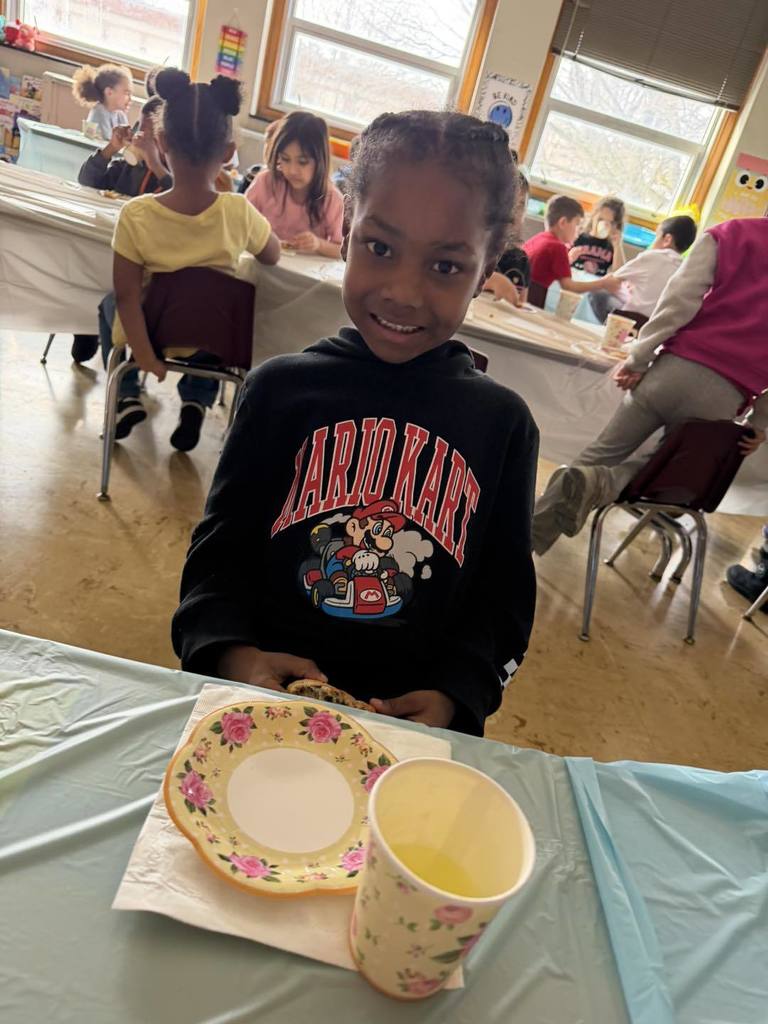 Kid smiling in a classroom. 