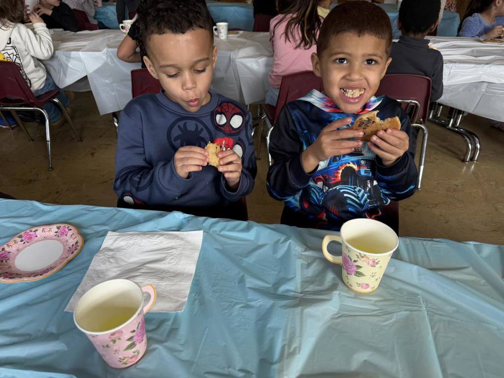Two young boys eating cookies. 