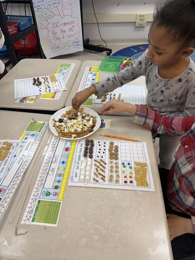 Kids taking snacks and putting them on a paper for a project.