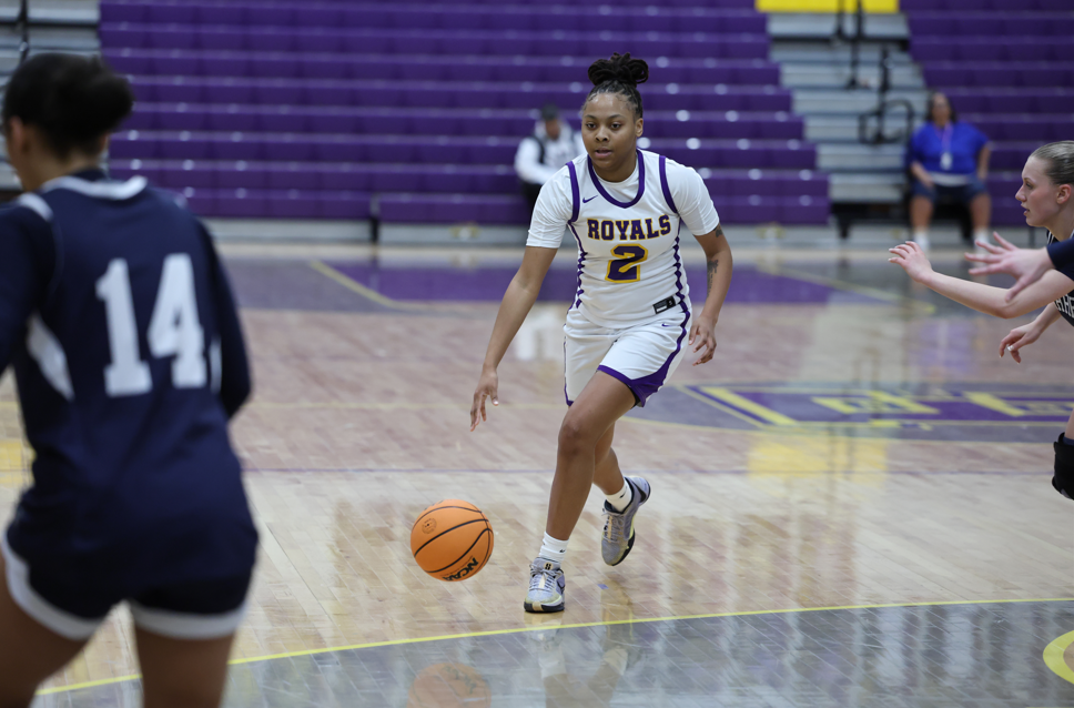 Lady's playing basketball on the court.