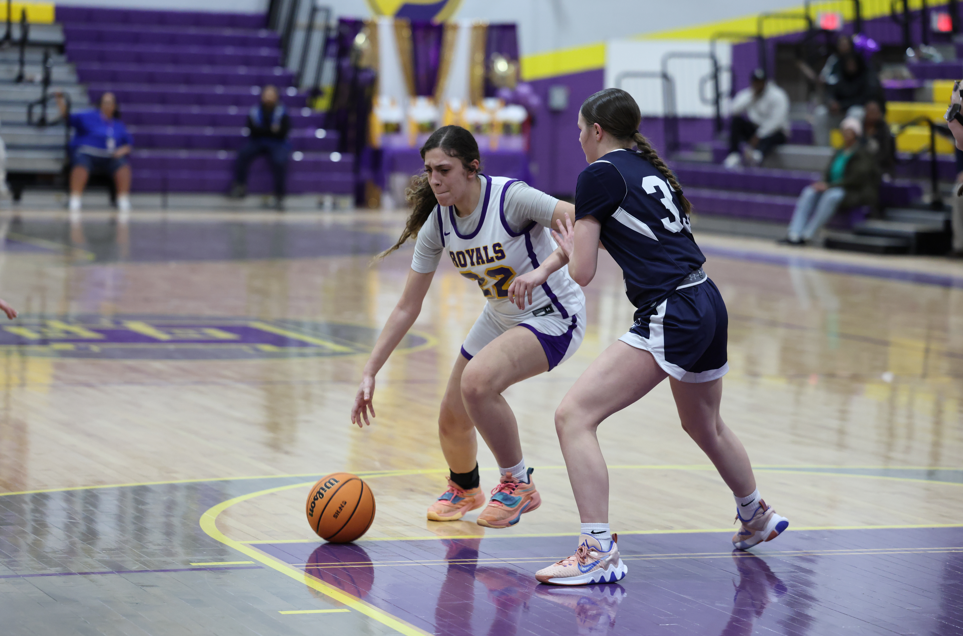 Lady's playing basketball on the court.
