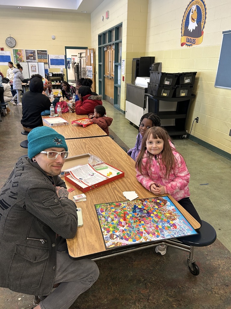 Kids and adults playing a board game.