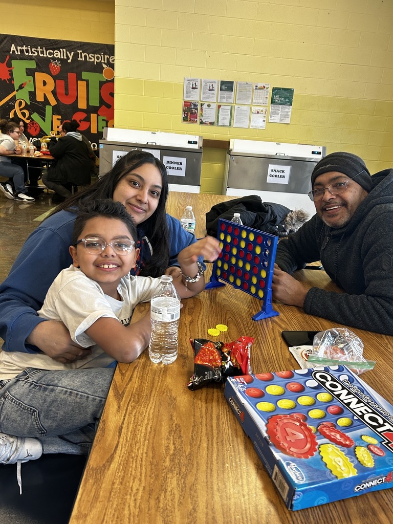 Kid and adults playing connect four.