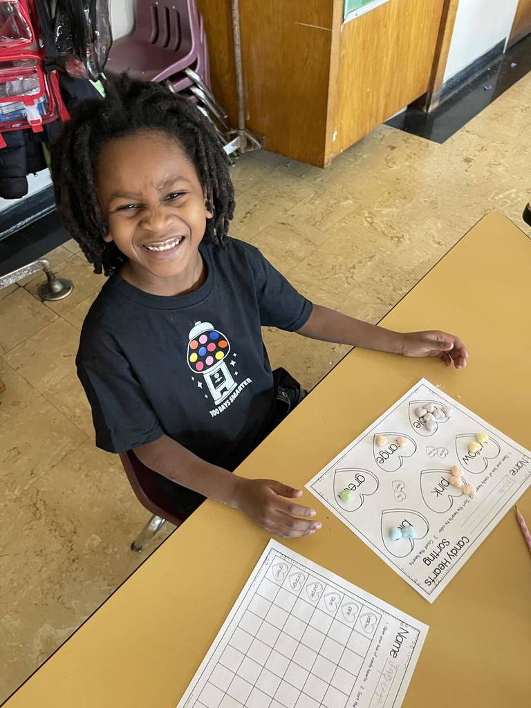 Student doing an activity in class, using candy and paper. 