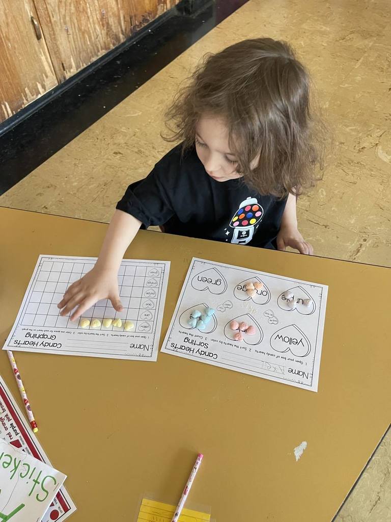 Student doing an activity in class, using candy and paper. 